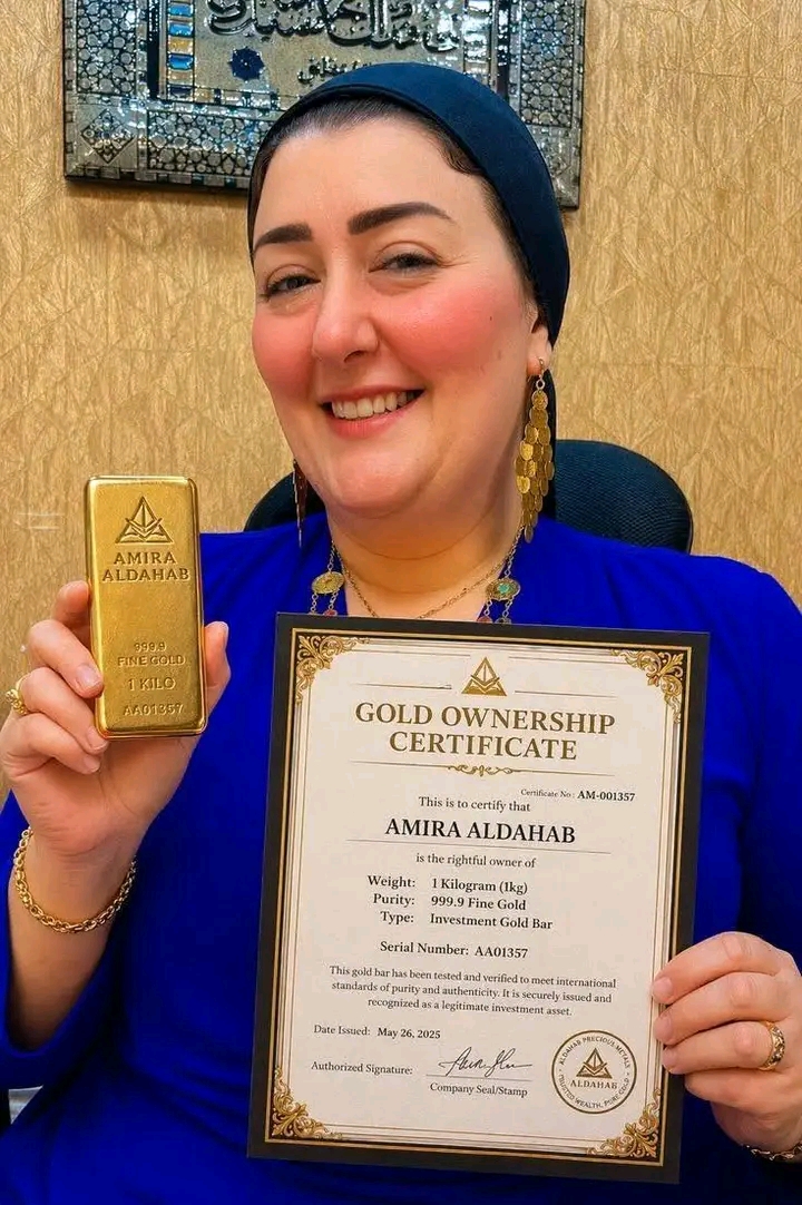 Amira Aldahab holding a gold ownership certificate
